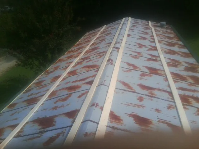 Rusted metal roof panels with new wood purlins before replacement — Storm Damage Roof Repair in Tennyson by Roofing Brothers